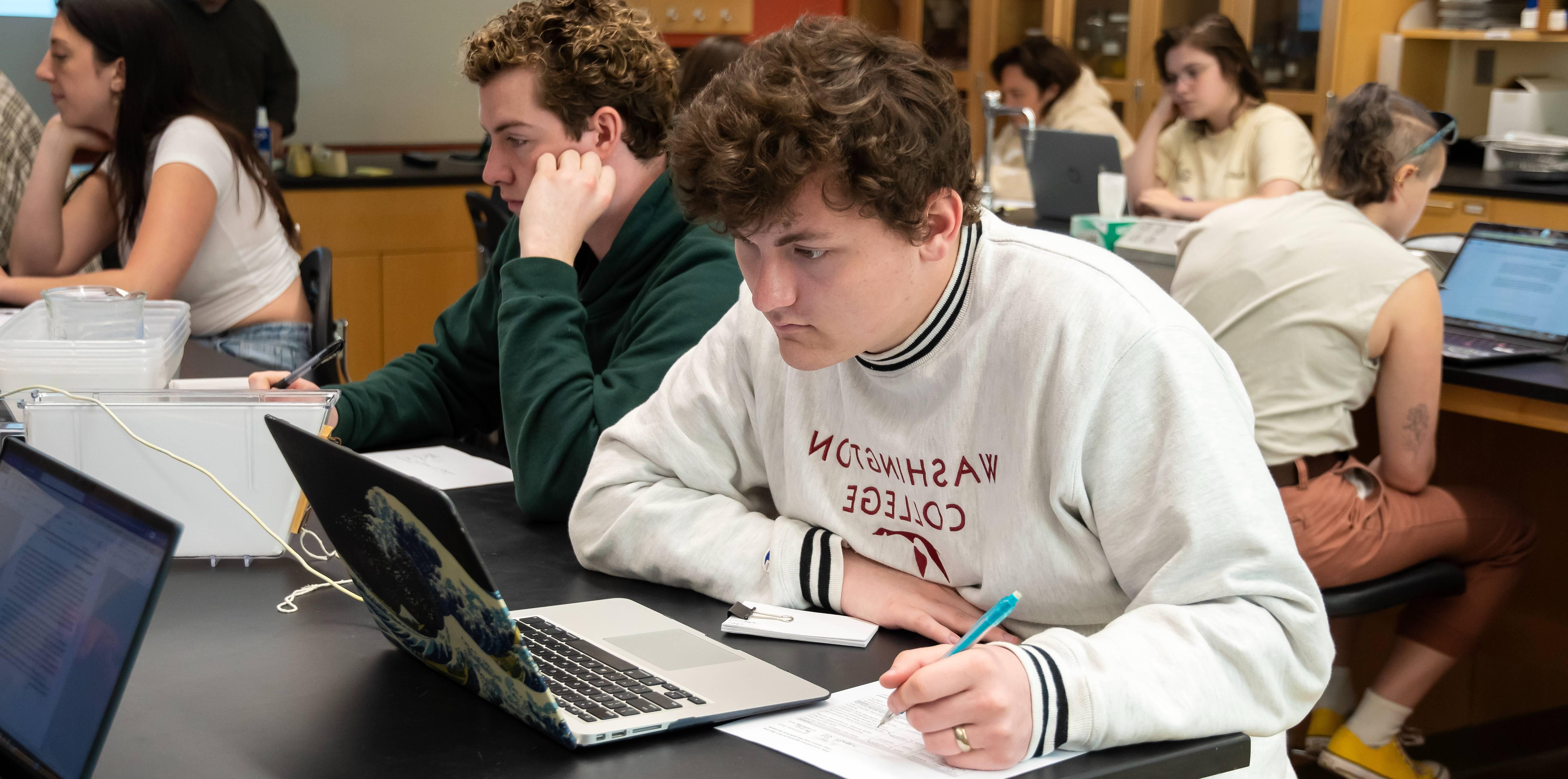 环境科学课上的学生在电脑屏幕上回顾信息